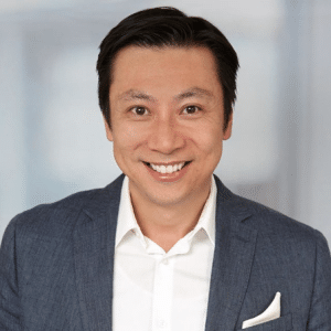Headshot of Hayden Lee smiling in a gray blazer and white dress shirt